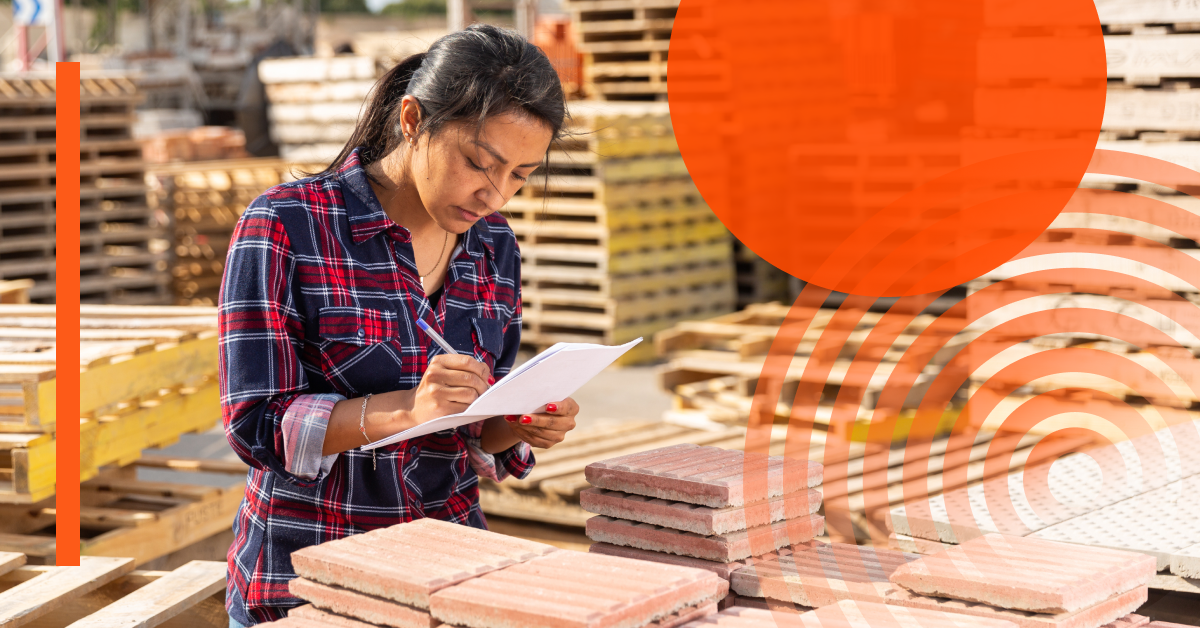 A person in a plaid shirt writes on a clipboard next to stacks of bricks at an outdoor construction supply area, with orange graphic overlays.