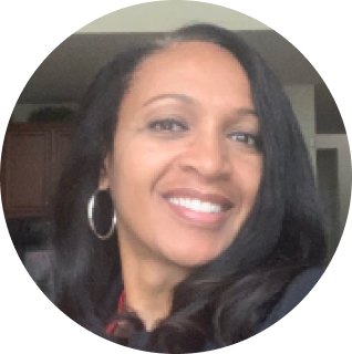 Smiling person with long black hair and hoop earrings in a circular frame.